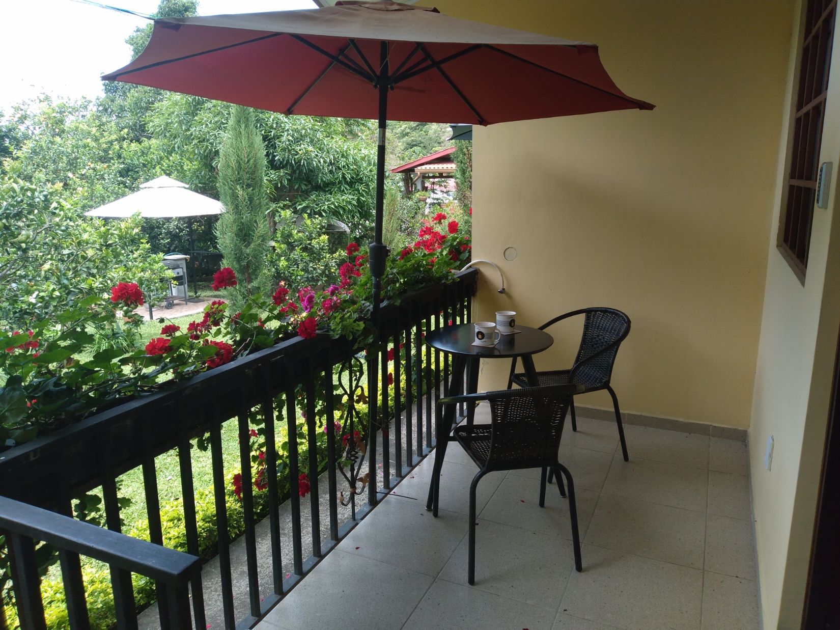 A table with two chairs and coffe cups on the terrace